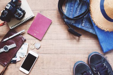 Treveler'ın öğeleri, temel tatil aksesuarları genç akıllı seyahat, seyahat kavramı ahşap arka plan üzerinde düz lay 