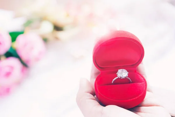 Donna mano tenuta fede fede nuziale in scatola rossa, matrimonio o fidanzamento concetto — Foto Stock
