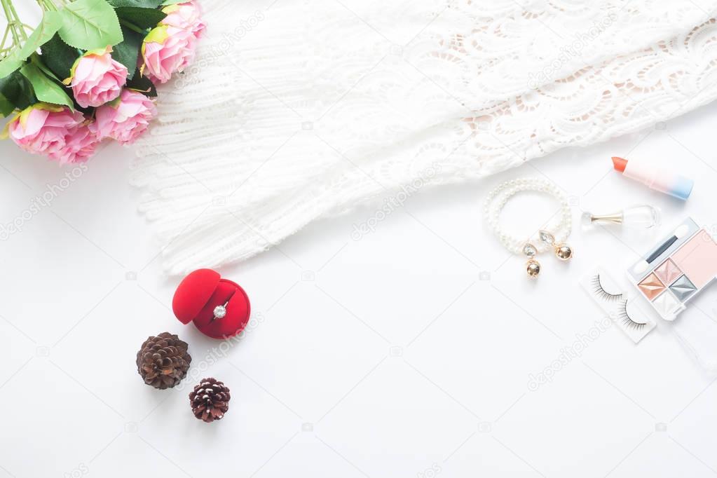 Flat lay of Bride essentials and engagement ring on white backgr