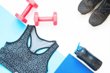 Spor aletleri spor giyim üzerine beyaz ve mavi arka plan ile yaratıcı düz lay