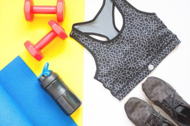 Spor aletleri spor giyim üzerine beyaz ve sarı bir arka plan ile yaratıcı düz lay