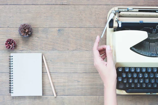 Creative płaskie ukształtowanie biurka vintage obszaru roboczego z kobietą ręce na maszynie do pisania, tekstury drewniane biurko — Zdjęcie stockowe