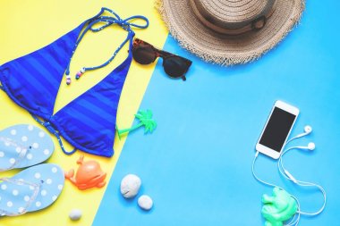 Düz kadın mayo ve aksesuarları ile smartphone, yaz kavramı yatıyordu