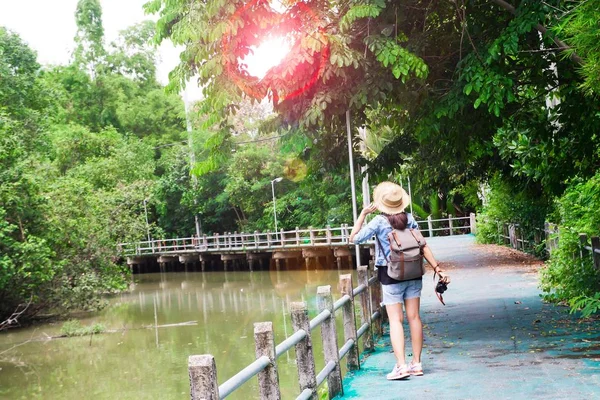 Hipster asiática chica con cámara respirando y mirando tropical pasarela y canal, Turista Viajero en Asia ubicación — Foto de Stock