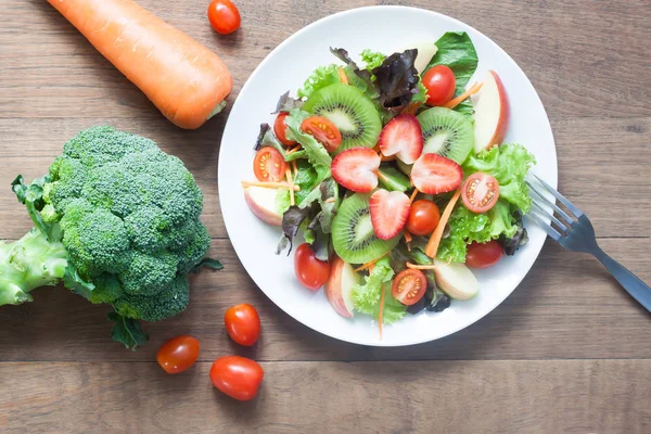 Fresh salad with strawberries, kiwi, tomatoes and apples, top vi