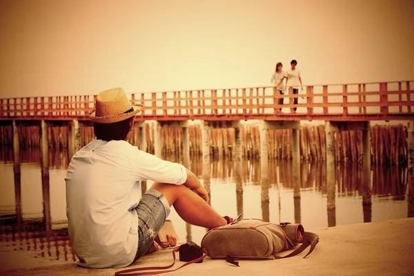 Asian broken heart man looking at lover on bridge, Vintage style color, Dark tone