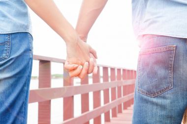 Yaz güneş, sevgi kavramı içinde çift rahat Jeans tutan eller