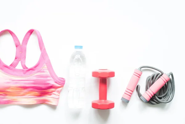 Sutiã esporte, garrafa de água e equipamentos de fitness no fundo branco, conceito de treino — Fotografia de Stock
