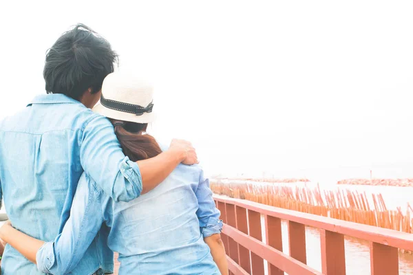 Happy asian couple in casual jeans hugging on wooden bridge by the sea, Summer travel, Happy lifestyle, Filter color with copy space