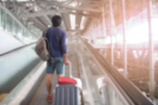 Размытый фон интерьера аэропорта с пассажиром перетаскивания багажа чемодан — стоковое фото