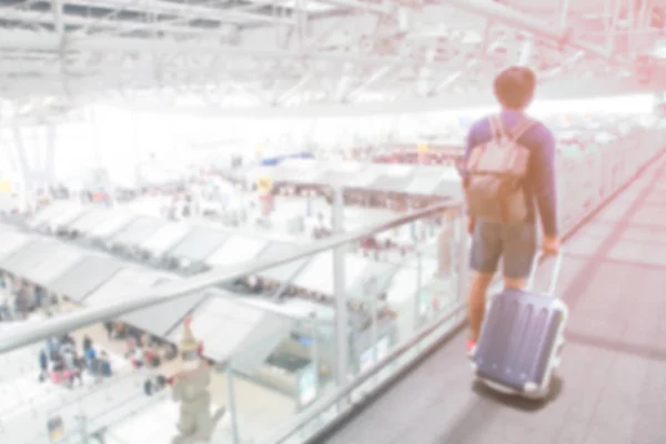 Abstrakte Unschärfe im Flughafeninnenraum: Reisender zerrt Gepäck — Stockfoto