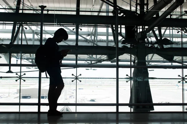 Warten am Flughafen, Smartphone, Silhouette Backpacker mit Technologie — Stockfoto