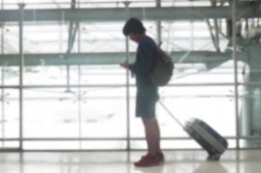 Bangkok, Tayland - 8 Ağustos 2017: Arka plan bulanık bir bavul yürüyüş geçitten Suvarnabhumi Airport adlı sürükleyerek adam. En popüler Se Asya Havacılık hub.