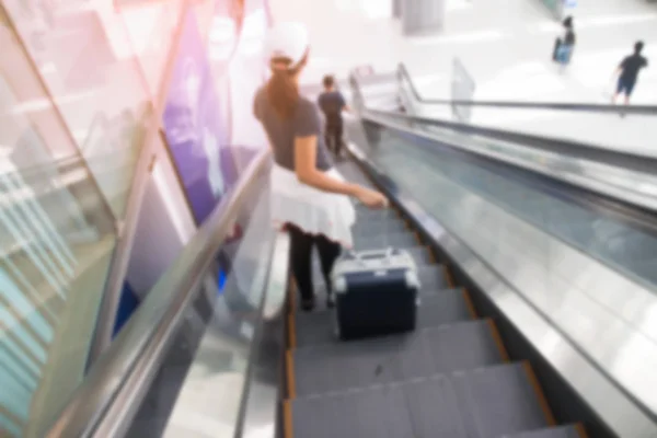 Bangkok, thailand - 8. August 2017: unklarer Hintergrund einer asiatischen Frau mit Koffer auf Rolltreppen am Flughafen Suvarnabhumi. das beliebteste asiatische Luftfahrtdrehkreuz. — Stockfoto