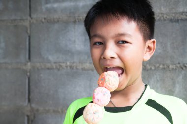 Mutlu ve komik Asya çocuk renkli donut topları yemek