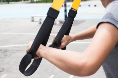 Kadının yapması süspansiyon eğitim, spor ekipmanları, Trx, spor ve fitness kavramı yakın çekim