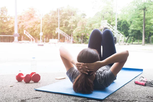 Genç ve çekici Asyalı kadın parkta, sağlıklı bir yaşam tarzı açık egzersiz yaparak