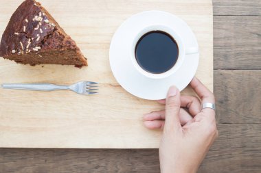 Bir fincan kahve ile bir pasta, yaşam tarzı ile kahve tutan kadın el