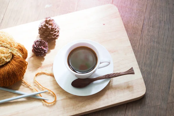 Uma xícara de café quente com um fio de tricô, cor da temporada de outono — Fotografia de Stock