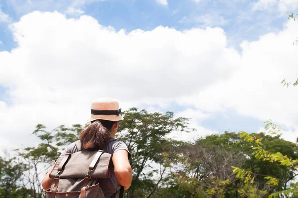 Mujer viajero con mochila mirando maravilloso bosque — Foto de Stock