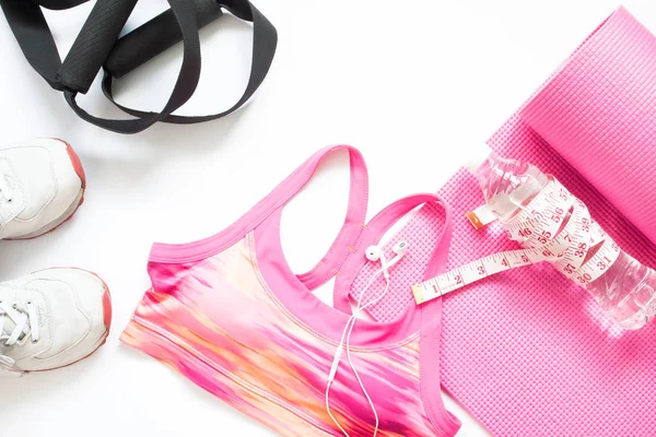 Düz spor ekipmanları pembe ve beyaz renk, spor salonu ve egzersiz kavramı yatıyordu.