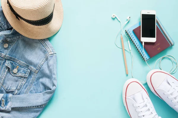 Mobil cihazla turist öğelerinin düz yatıyordu, pasaport ve giyim üzerine pastel renk arka plan