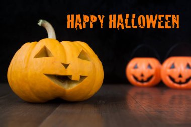 Halloween pumpkins ahşap zemin ve mutlu halloween metin ile koyu arka plan ile natürmort