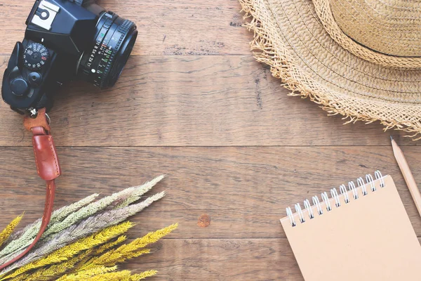 Diseño plano creativo del concepto de otoño con flores secas, cámara, sombrero de paja y cuaderno sobre fondo de madera — Foto de Stock