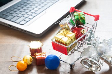 Hediye alışveriş sepeti ve Noel dekorasyonları ahşap masa, Online alışveriş dizüstü bilgisayar ile kutuları