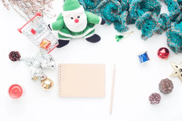 Cuaderno en blanco y lápiz sobre mesa blanca con decoraciones navideñas y carrito de compras, Vista superior — Foto de Stock