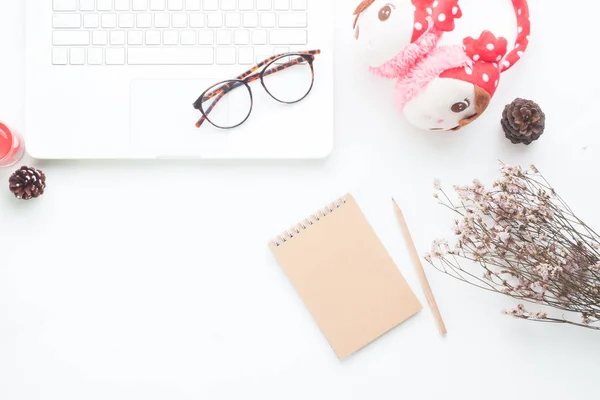 Creative flat lay of feminine working space with laptop computer, notebook, dried flower and accessories