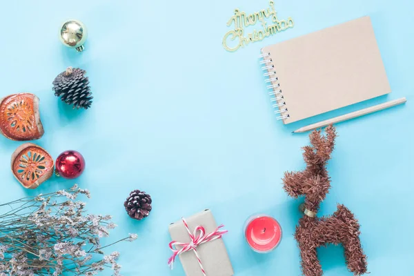 Diseño plano creativo de cuaderno de manualidades, adornos navideños y cajas de regalo sobre fondo de color pastel con espacio para copiar — Foto de Stock
