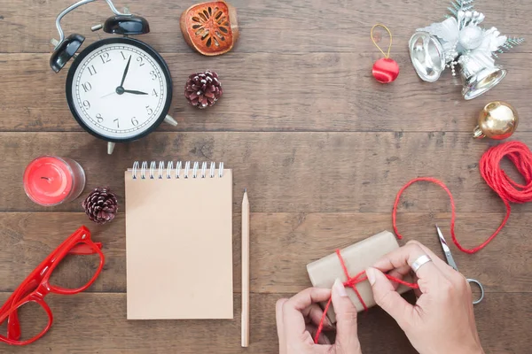 Vista aérea del concepto de Navidad y Acción de Gracias, manos de mujer decorando caja de regalo sobre fondo de madera — Foto de Stock