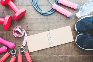 Fitness ve kilo kaybı kavramı, halter, ip atlama ve ölçme-kasette ahşap arka plan, üstten görünüm