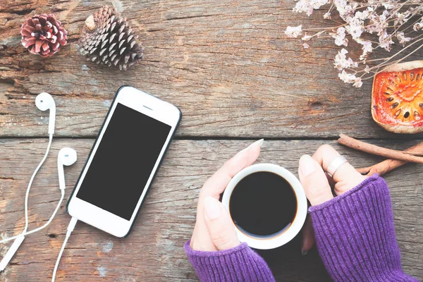 Modèle de téléphone intelligent avec les mains de la femme tenant une tasse de café chaud f — Photo