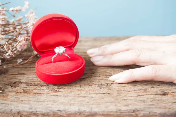 Anello diamante in scatola rossa con mano donna sul tavolo di legno, Anello di fidanzamento, San Valentino — Foto Stock