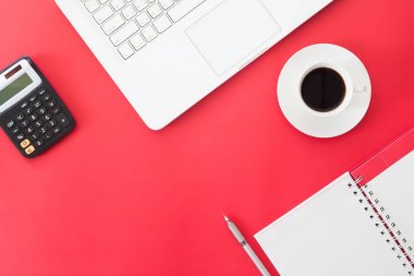Yaratıcı düz lay iş ve Online alışveriş kavramı, dizüstü bilgisayar, fincan kahve, hesap makinesi ve defter üzerinde kırmızı renk arka plan, çalışma alanı, Online Pazarlama