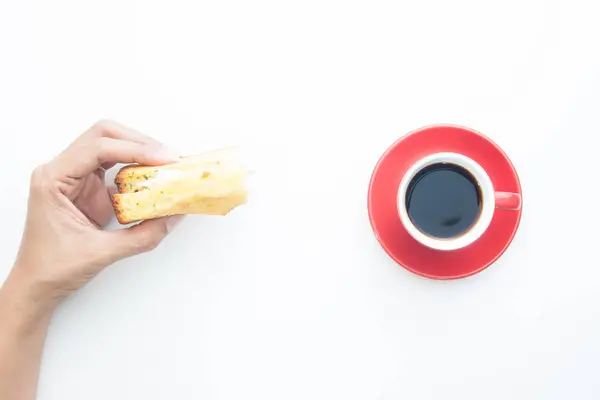 Directement au-dessus de la main femme tenant sandwich avec tasse de café isolé sur fond blanc — Photo