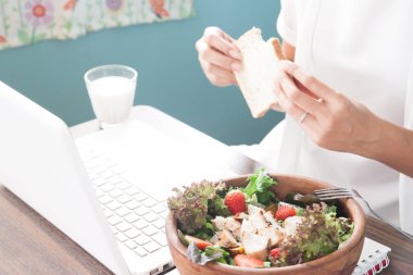 Sabah yemek, seçici ile çalışan kadın arka planda ekmek dilimlenmiş odaklanmak salata ve tutan kadın