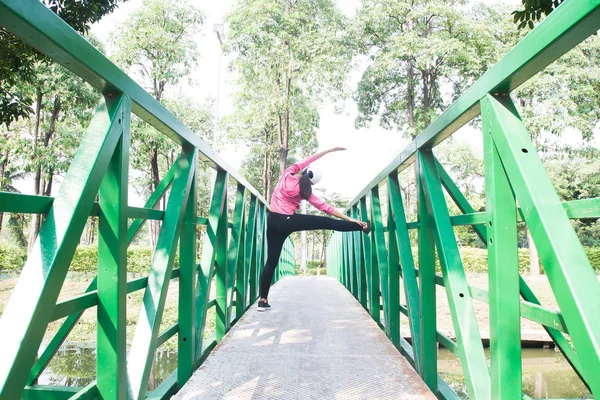 Mujer sana con camisa deportiva rosa haciendo ejercicio en el parque, Disparo en el puente, Bienestar, estilo de vida feliz — Foto de Stock