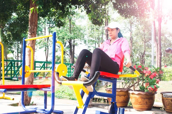 Mujer asiática de 40 años haciendo ejercicio con equipos de entrenamiento en el parque público, estilo de vida saludable, concepto de belleza — Foto de Stock