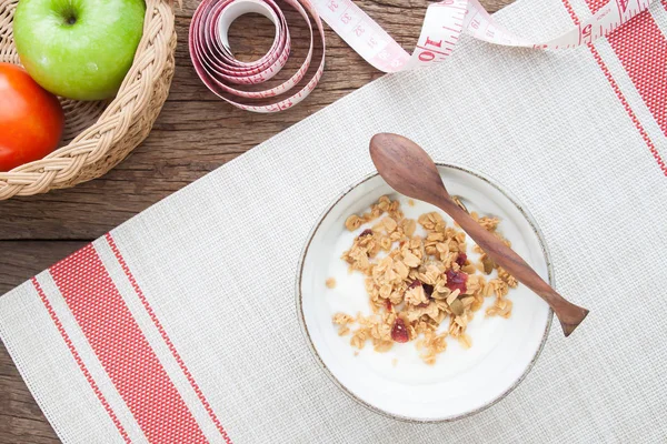 Yogur con granola en un tazón, manzana y tomate sobre mesa de madera, concepto saludable y dietético —  Fotos de Stock