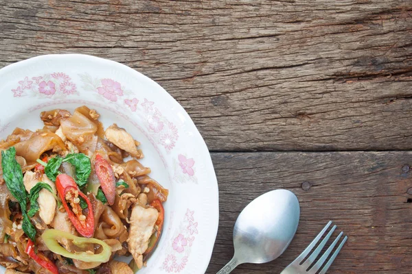 Nouilles plates épicées sautés sur fond bois, vue sur le dessus, cuisine thaïlandaise — Photo