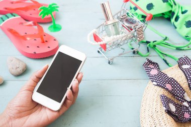 Kadının el holding cep telefonu ile alışveriş sepeti ve aksesuar arka plan, yaz kavramı, Online alışveriş