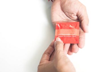 Beyaz arka plan, sağlık ve güvenli seks izole man's taraftan kadın vermek prezervatif