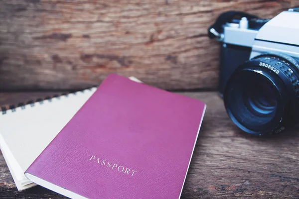 Κοντινό πλάνο του διαβατηρίου και vintage φωτογραφική μηχανή ταινία σε ρουστίκ ξύλινα πίνακα, έννοια του ταξιδιού — Φωτογραφία Αρχείου