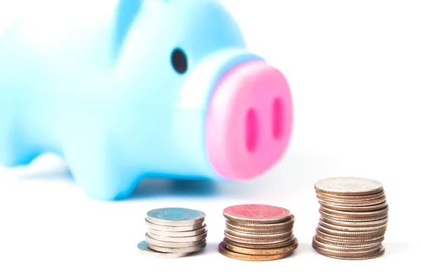 Close-up van de stapel van munten en piggy bank op wit, financiën, geld, sparen voor de toekomst concept Stockafbeelding