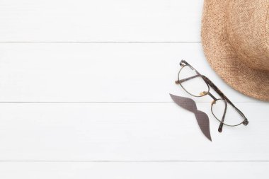 Yaratıcı düz bıyıkları, gözlük ve hasır şapka işareti Beyaz ahşap arka plan üzerinde Babalar günü kavramı yatıyordu.