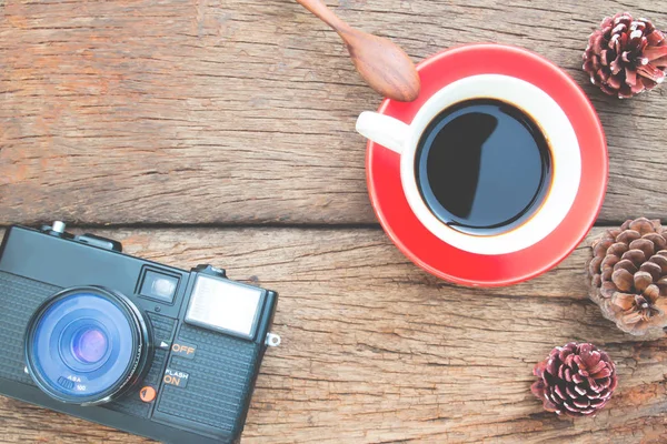 Kopp kaffe och film kamera på rustika träbord, platt lay, mysig och Vintage stil — Stockfoto