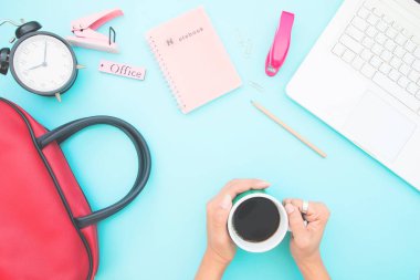 Kahve fincanı tutan kadının el ile çalışma masası havai görünümü